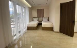 a bedroom with two beds and a large window at Makaryan Resort in Artsvaberd