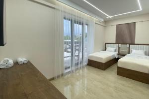 a hotel room with two beds and a large window at Makaryan Resort in Artsvaberd