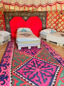two beds in a yurt with a colorful rug at Mars Canyon Yurt Camp in Tong +18 photos