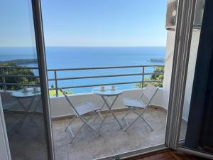 a balcony with a table and chairs and the ocean at Sea Time Apartment in Budva