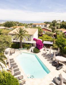an overhead view of a swimming pool with lounge chairs and a resort at Hôtel La Villa Cap d’Antibes in Juan-les-Pins