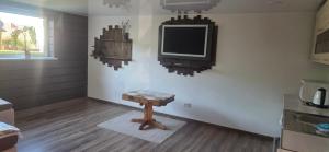 a room with a tv on a wall with a table at Pas Jolantą in Ignalina