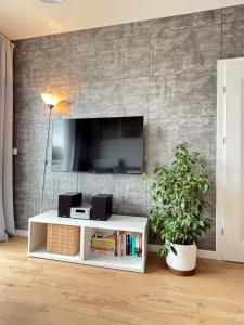 a living room with a tv on a wall at Marigold Apartment Łódź in Łódź