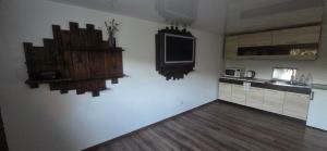 a kitchen with a tv on the wall and a counter at Pas Jolantą in Ignalina +4 photos