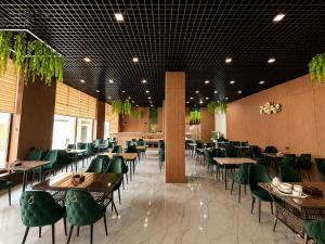 a dining room with tables and green chairs at HUMO PLAZA in Fergana