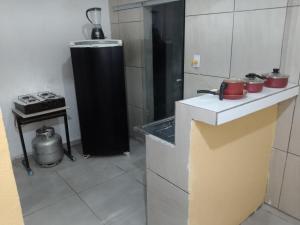 a kitchen with a refrigerator and a stove at Pousada Nordestino in Salinópolis