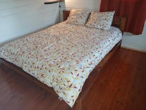 a bed with a comforter and two pillows on it at Les Chalets de COCO in Saint-Leu
