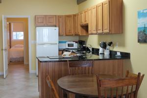 a kitchen with a table and a white refrigerator at The Inn on the Wharf in Lubec