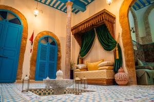 a room with a bed in a room with blue doors at Riad Le Cheval Blanc in Safi