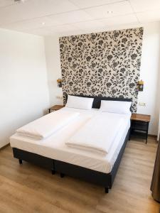 ein Schlafzimmer mit einem Bett mit schwarz-weißer Tapete in der Unterkunft Hotel Constantin Trier in Trier