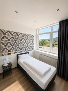 ein Schlafzimmer mit einem großen Bett und einem Fenster in der Unterkunft Hotel Constantin Trier in Trier
