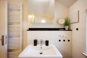 a bathroom with a white sink and a mirror at Ferienwohnung Fuchsfelsen, perfekt für Familien mit Kindern in Häusern +27 photos