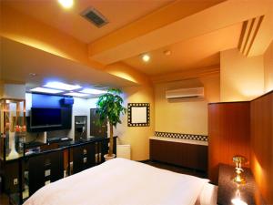 a bedroom with a bed and a flat screen tv at Hotel RR (Adult Only) in Yokkaichi