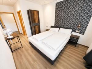 ein Schlafzimmer mit einem großen weißen Bett und einem Tisch in der Unterkunft Hotel Constantin Trier in Trier