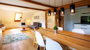 a dining room and living room with a table and chairs at Ferienwohnung Fuchsfelsen, perfekt für Familien mit Kindern in Häusern
