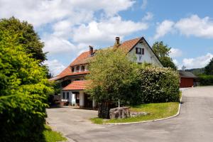 a house with a tree in front of a street at Ferienwohnung Fuchsfelsen, perfekt für Familien mit Kindern in Häusern
