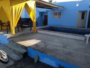 a patio with a yellow curtain and a swimming pool at Pousada Nordestino in Salinópolis