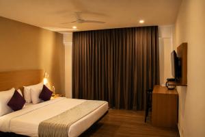 a hotel room with a bed and a television at Hotel The Golden Sands, Located on Calangute Main Road in Calangute