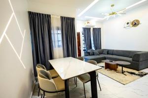 a living room with a table and a couch at Luz RÉSIDENCE in Abomey-Calavi