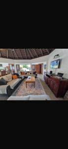 a living room with a couch and a table at Reef Winds Villa in Runaway Bay