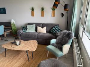 a living room with a couch and a table at Ferienwohnung Sundkieker Fehmarn in Fehmarn +10 photos