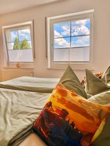 a bedroom with two beds and two windows at Schnütgenhof Appartements in Attendorn