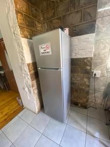 a refrigerator in a room with a brick wall at Keetmanshoop Self-catering in Keetmanshoop