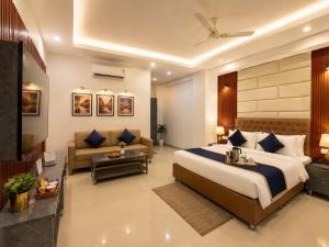 a hotel room with a bed and a couch at Hotel Kasa Stays Premier - Peeragarhi Metro Station in New Delhi +6 photos