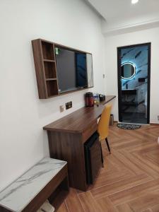 a room with a desk with a tv and a chair at Furaton Hotel in Ðức Hòa