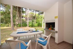 Un patio con mesa y sillas y una chimenea. en Villaggio Paradiso, en Bibione