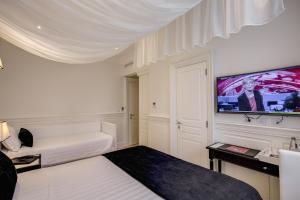 a white room with a bed and a flat screen tv at Hotel Tito in Rome