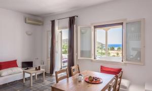 a living room with a table and chairs and a couch at Mylopota apartment IIΙ in Mylopotas +71 photos