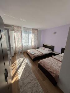 a hotel room with two beds and a window at Къща за гости "Пердика" in Obzor
