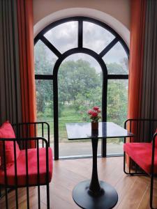 a room with a table and a large window at Furaton Hotel in Ðức Hòa