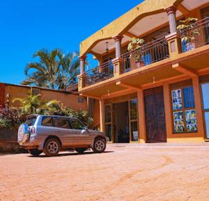 a car parked in front of a building at Golden Quest Hotel in Entebbe