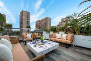 a patio with couches and a table on a balcony at Secluded Comfort City Resort Hotel in Hangzhou