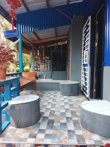 a patio with two benches and a bath tub at Lhady Roxy in Siquijor