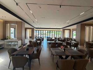 a restaurant with tables and chairs and windows at Hotel Roden in Golem