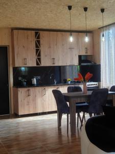 a kitchen with a wooden table and chairs in a room at George - Guest House Shekvetili in K'vemo Natanebi