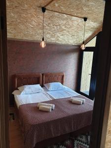 a bedroom with a bed with two towels on it at George - Guest House Shekvetili in K'vemo Natanebi