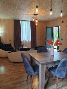 a dining room with a table and a couch at George - Guest House Shekvetili in K'vemo Natanebi