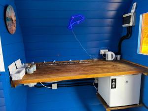 a bathroom with a blue wall with a sink at Glamping Pod in Milltown Malbay