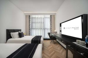 a hotel room with a bed and a flat screen tv at Secluded Comfort City Resort Hotel in Hangzhou