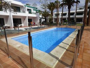 a swimming pool in front of a building at Departamento Maria in Puerto del Carmen