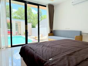 a bedroom with a bed and a view of a pool at Nook Villa in Ban Khlong Mae Nam +73 photos