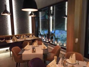 a restaurant with tables and chairs and a large window at Apartment Ski Star Konaci in Kopaonik