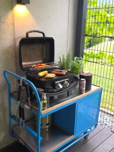a grill with hot dogs and sausages on a cart at Lieblingsplatz Alpine Lodge in Tschagguns