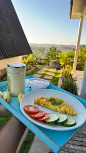 a plate with a slice of pizza and vegetables on a table at Payas Private Farm Villa in Praya +9 photos