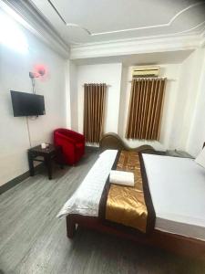 a bedroom with a large bed and a red chair at HoTeL Long Phụng 1 Quận Bình Tân in Ho Chi Minh City