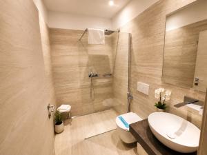 a bathroom with a shower and a toilet and a sink at Athos Hotel in Riva del Garda